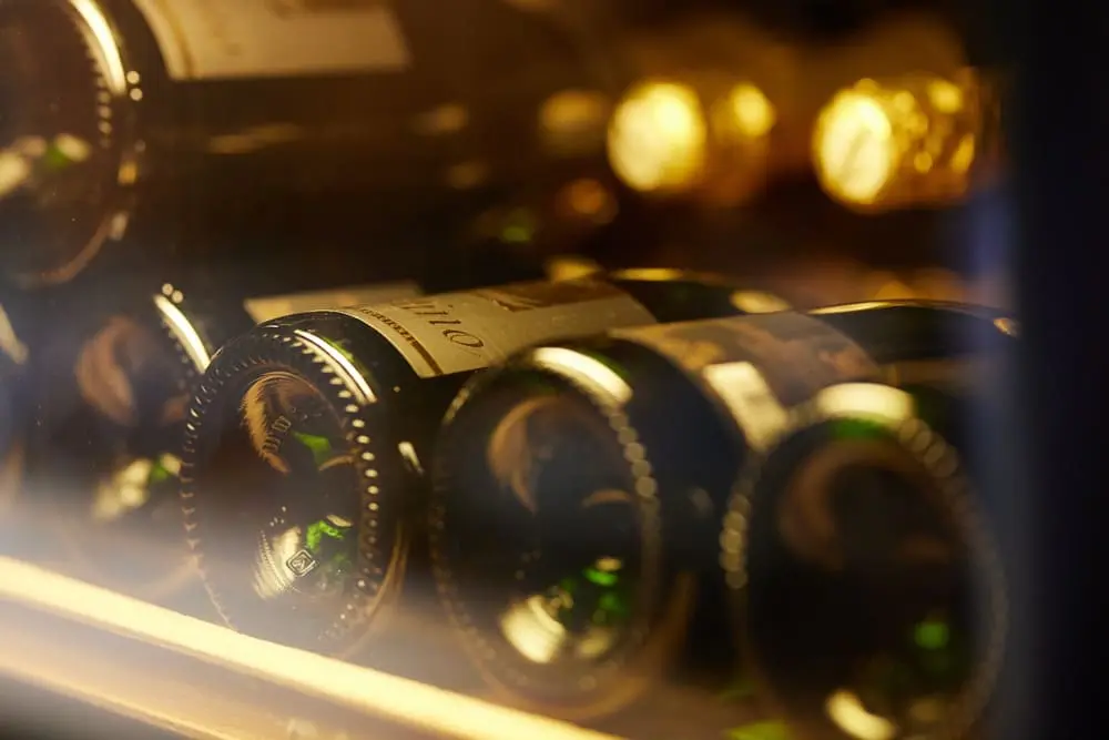A view of wine bottles being kept at the best temperature within a wine refrigerator A view of wine bottles being kept at the best temperature within a wine refrigerator.