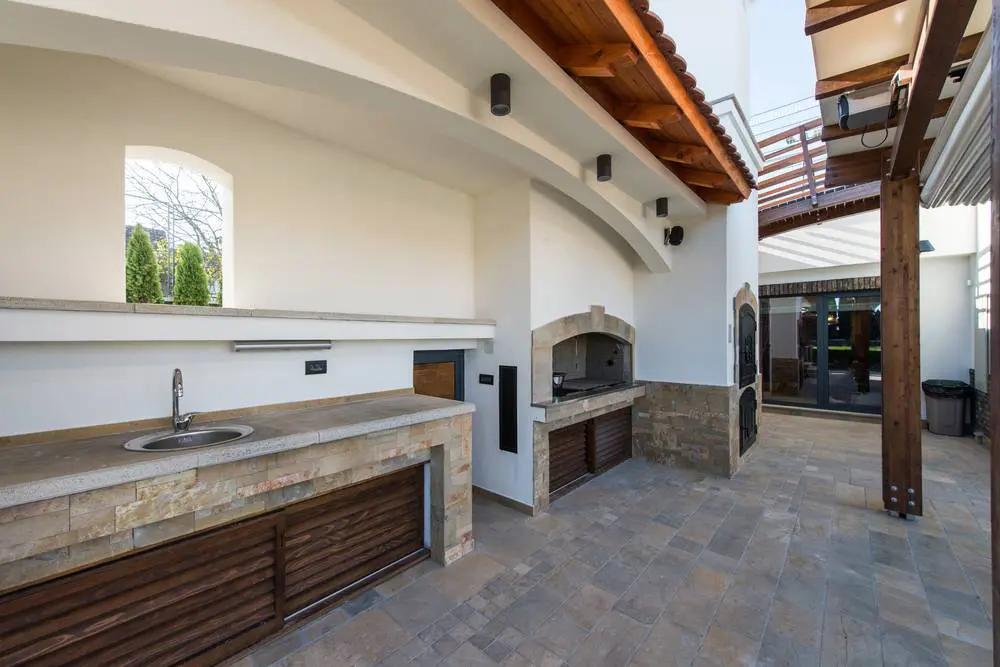 A completed backyard bar design featuring a pizza oven, under-counter storage, and a kitchen sink.