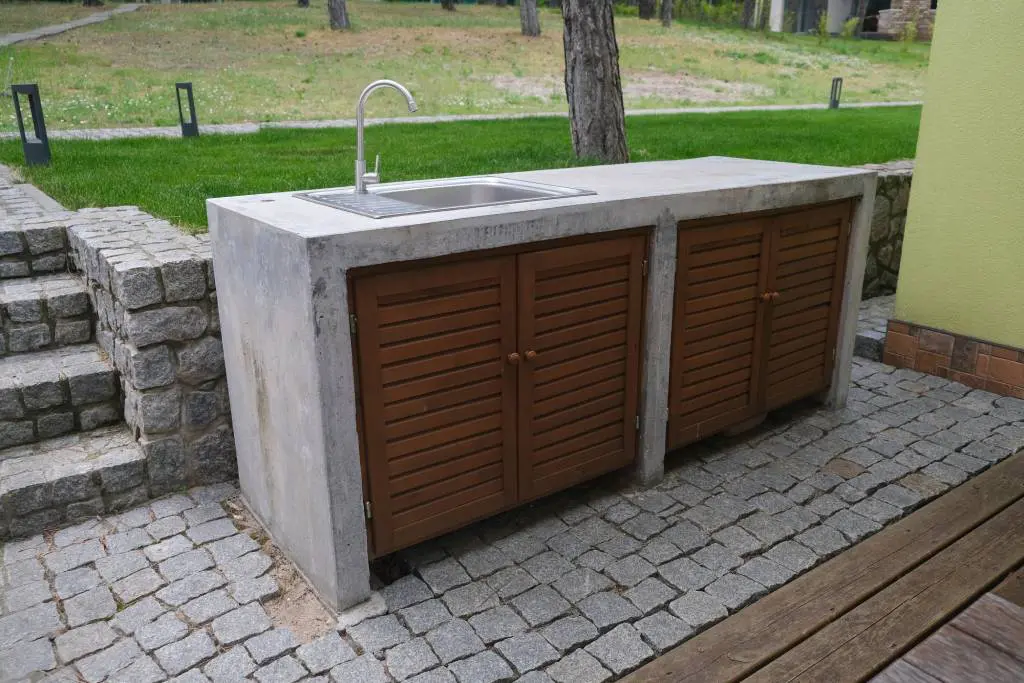 A more rustic, yet simplistic outdoor sink installation on a smaller workspace outside.