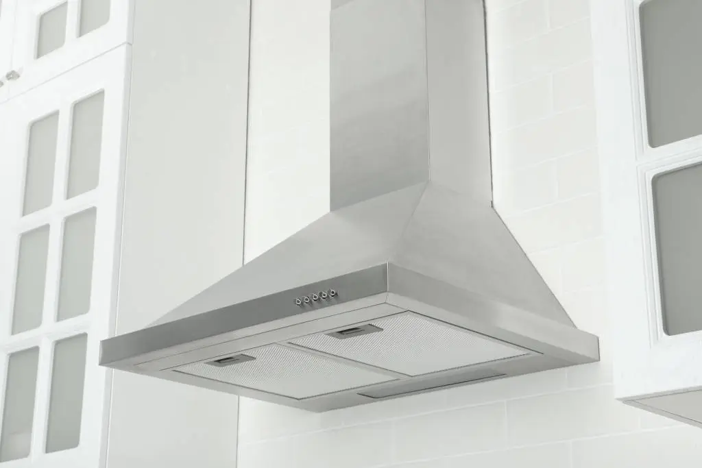 Modern stainless steel range hood vent installed through a kitchen ceiling Modern stainless steel range hood vent installed through a kitchen ceiling, illustrating a finished example of proper ceiling-mounted ventilation