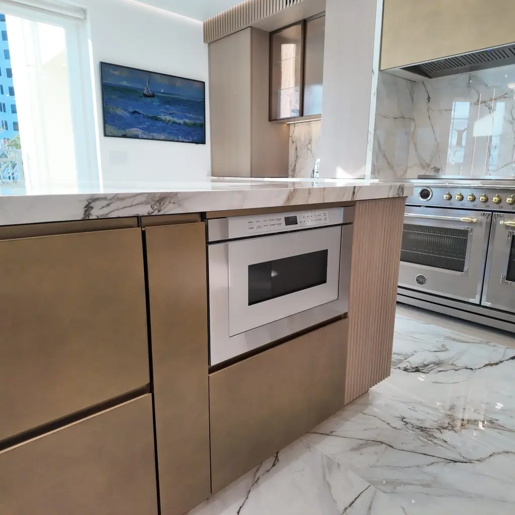 XO microwave drawer installed in a kitchen island with a marble countertop