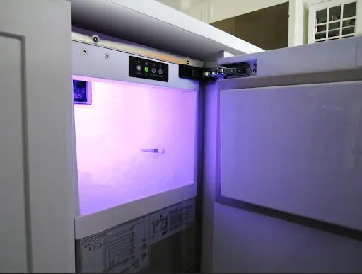 XO ice maker open with illuminated ice bin and controls